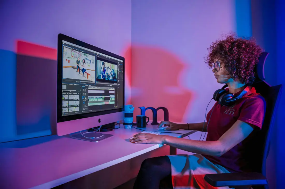 An editor cutting a video on a big screen