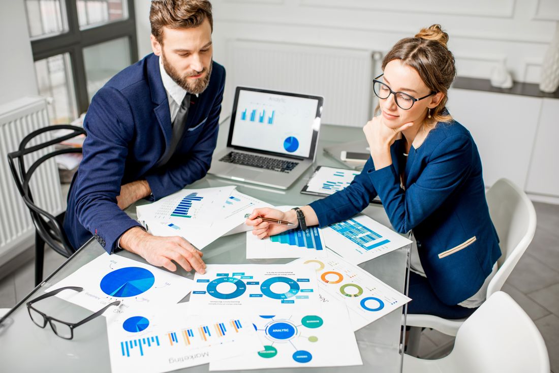 Two people reviewing marketing reports