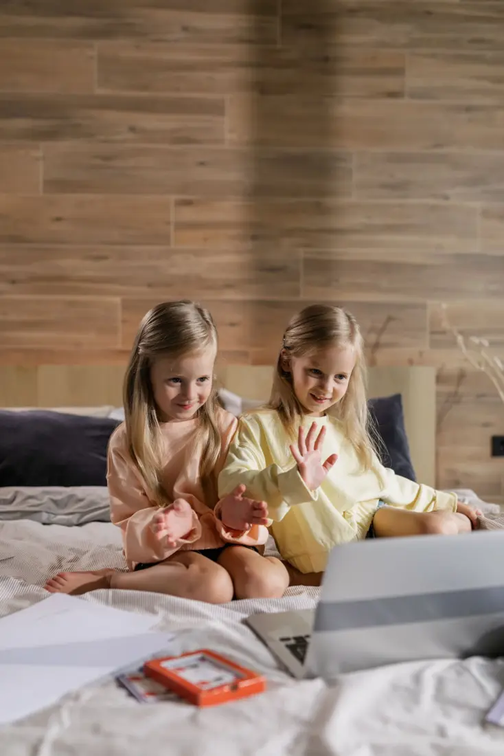 Two girls waving at a video call